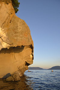 Sea kayaking under sculpted sandstone cliffs by Kevin Oke