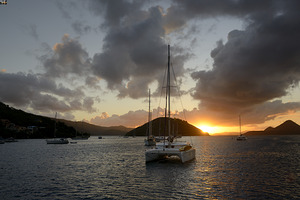 Caribbean sunset with catamarans and sailboats 