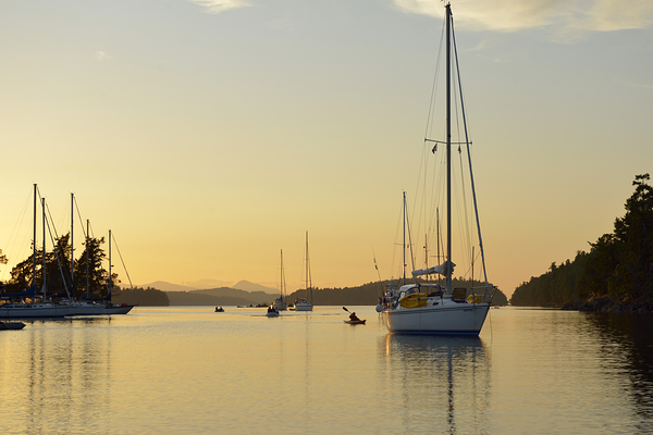 Sea kayaker and anchored boats in Princess Bay Print