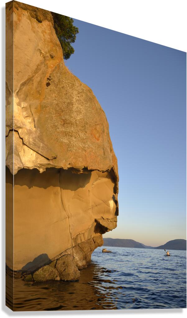 Sea kayaking under sculpted sandstone cliffs Canvas Print