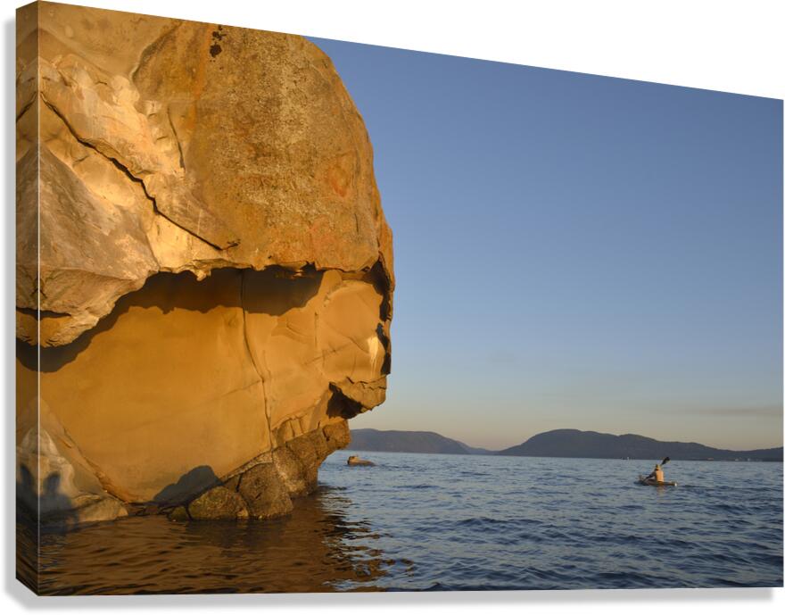 Sea kayaking under sculpted sandstone cliffs Canvas Print