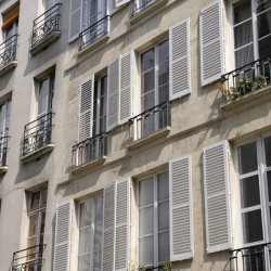 Apartment windows with open shutters and balconies - Paris