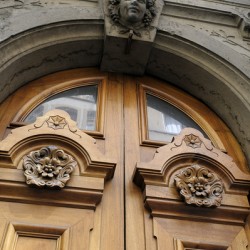 Wooden door with carved figurine in stone above it. France