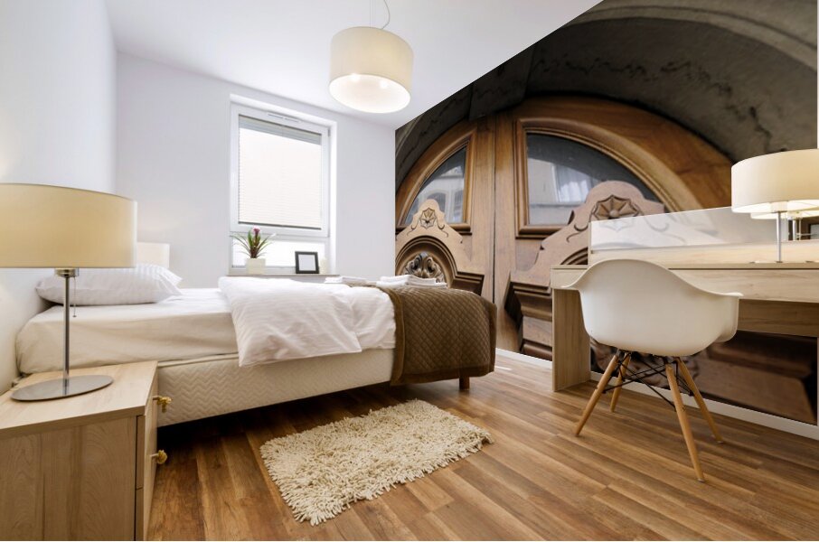 Wooden door with carved figurine in stone above it. France Mural print