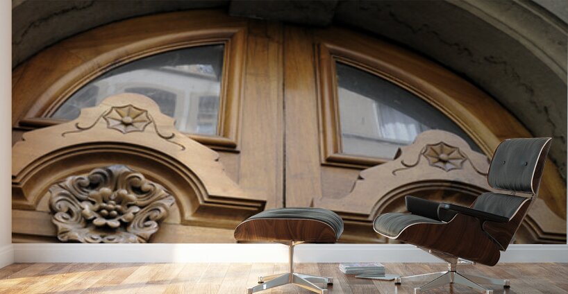 Wooden door with carved figurine in stone above it. France Wall Murals