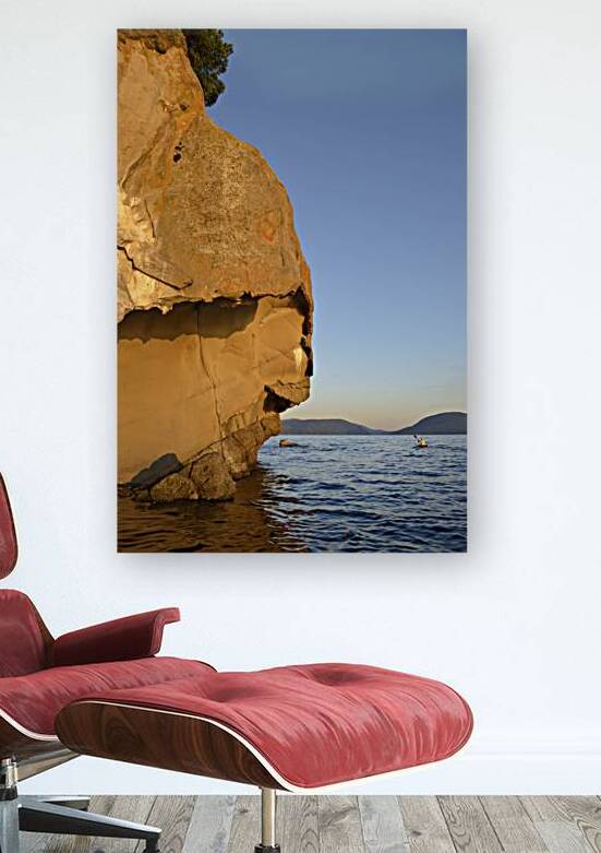 Sea kayaking under sculpted sandstone cliffs by Kevin Oke